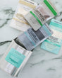 All four masks in the Face Mask Gift Set — Dead Sea Mud, CharClay, Oatbrasion and Cafe Mocha — laid out on marble. Rinse Bath & Body Co.