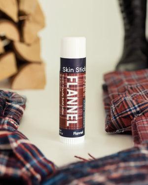 Flannel solid lotion stick uncapped, showing the poured lotion bar inside its tube. Rinse Bath & Body Co.