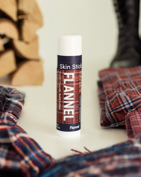 Flannel solid lotion stick uncapped, showing the poured lotion bar inside its tube. Rinse Bath & Body Co.