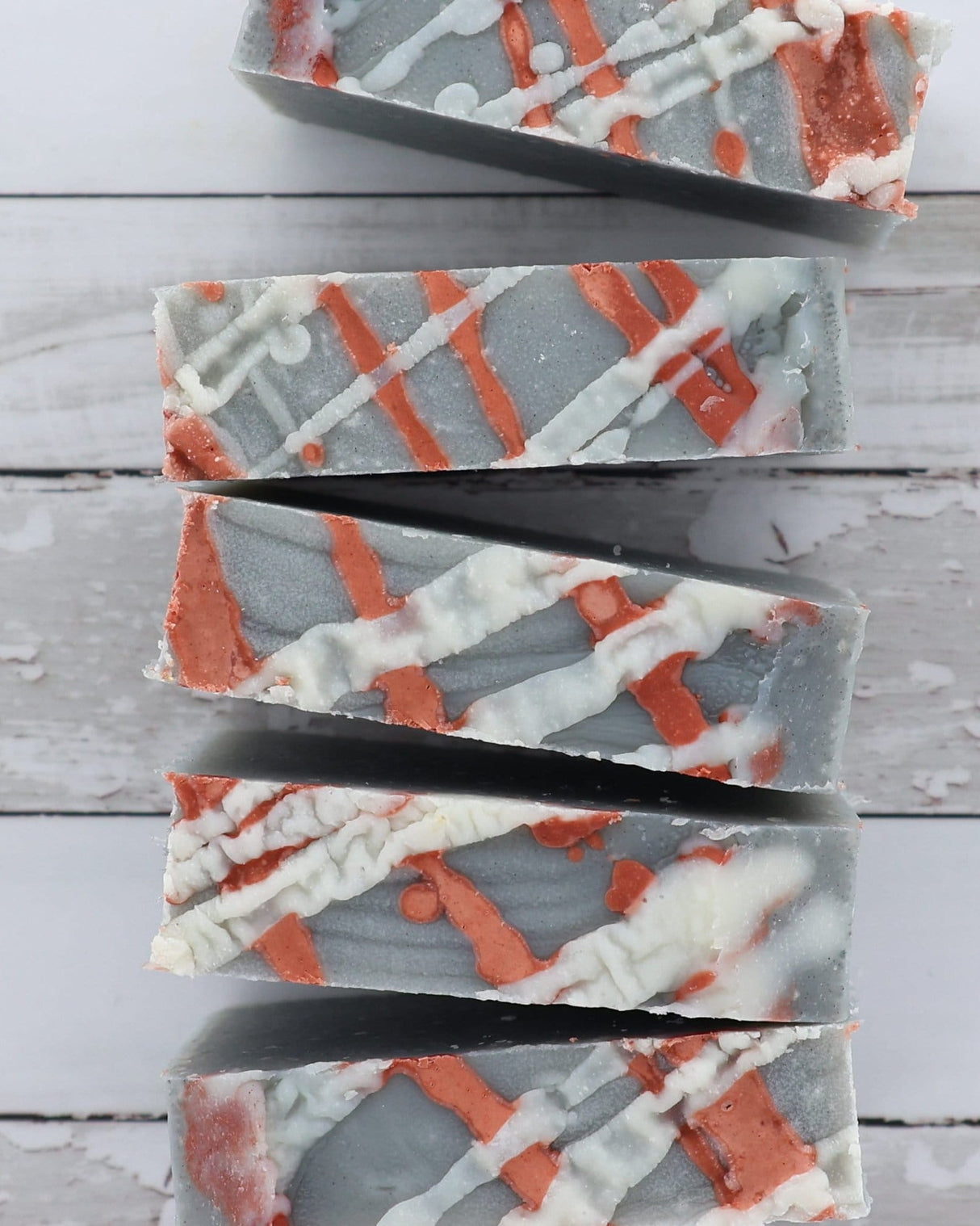 Flannel bar soap with its red plaid label and charcoal swirl running through the pour. Rinse Bath & Body Co.