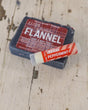 Dark Flannel soap with Peppermint Pucker Stick across its corner — weathered whitewashed wood in rustic light