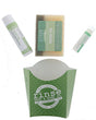 The Fresh Fig set laid out flat — bar soap, Fresh Fig solid lotion skin stick and Speppermint lip balm above the green printed carton. Rinse Bath & Body Co.