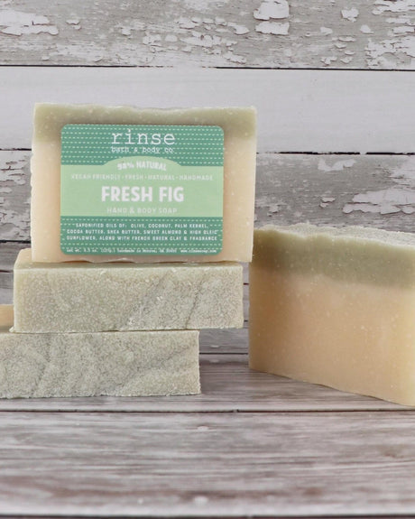 Fresh Fig bar soap with its pale green swirl through the pour, label facing out. Rinse Bath & Body Co.