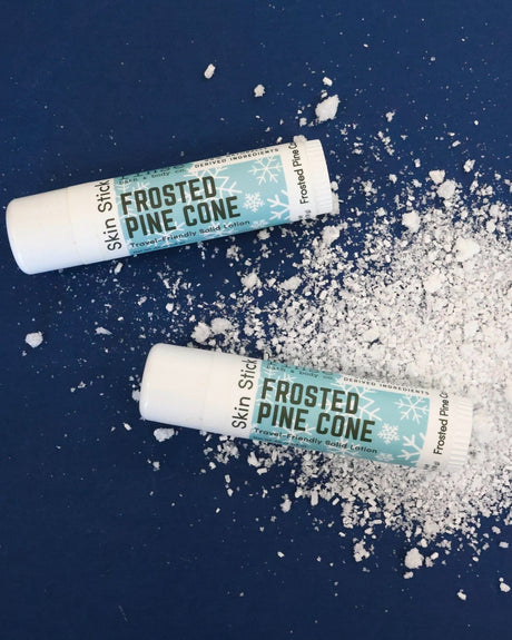 Frosted Pine Cone Skin Stick packshot stylized — cold winter evergreen twist-up moisture bar on snowy navy
