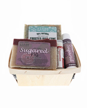 Frosted Pine and Sugared Fig holiday berry till packed with Peppermint balm and Skin Stick — wooden basket on bright white