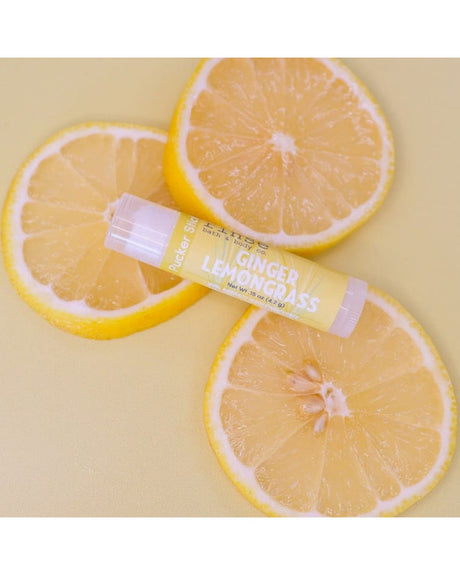 Ginger Lemongrass Pucker Stick nestled among bright lemon slices — citrus lip balm close-up
