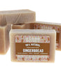 Gingerbread soap stylized flat lay — creamy tan bars with sprinkle labels stacked on bright white