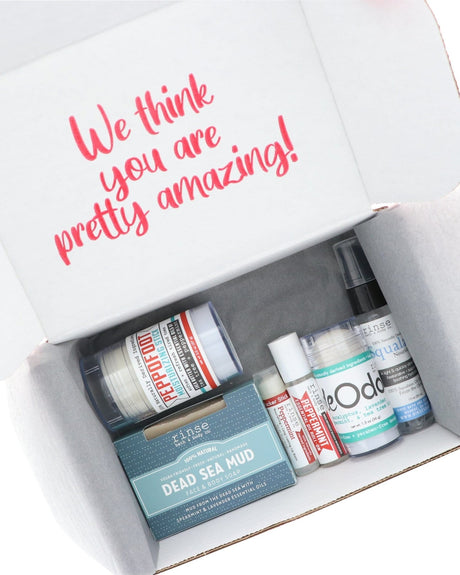 An open Going Natural discovery box with its products arranged inside and the printed flap reading “We think you are pretty amazing!” — six full-size Rinse products, ready to give as shipped. Rinse Bath & Body Co.