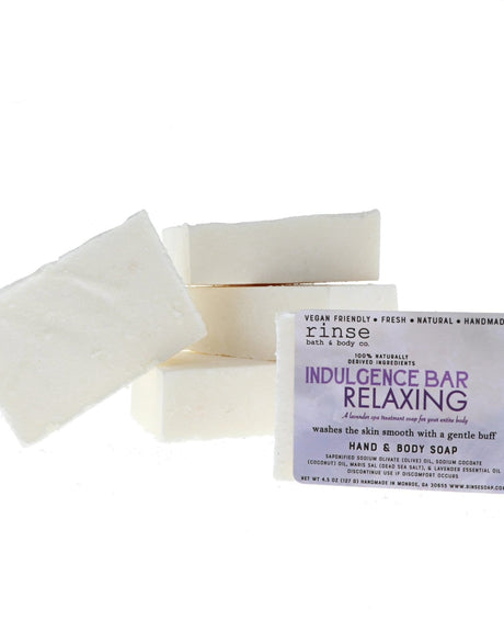 Indulgence Bar Relaxing soaps stacked on bright white — purple label and creamy bars in clean studio light