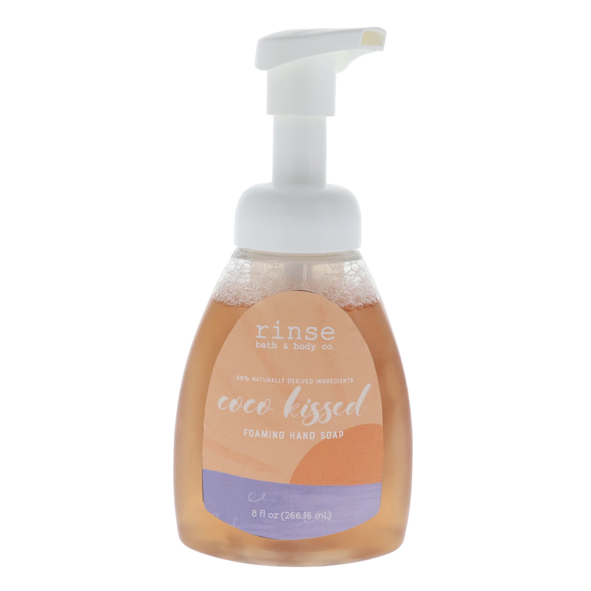 Coco Kissed foaming soap bottle stands centered — peach wavy label and amber liquid on white