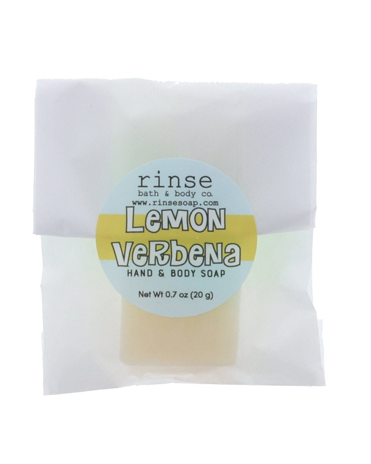 Lemon Verbena soap slice in translucent glassine — yellow-blue circle sticker on clean bright white