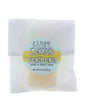 Lemon Verbena soap slice in translucent glassine — yellow-blue circle sticker on clean bright white