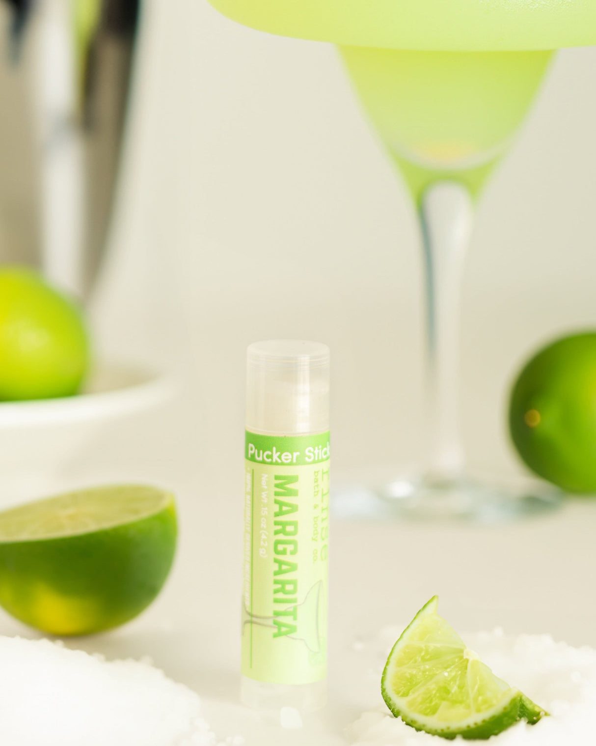 Margarita lip balm styled with lime — fresh-squeezed lime and salt in a twist-up balm. Rinse Bath & Body Co.