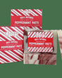 Peppermint Patti mini soaps before candy-cane striped cartons — cream and chocolate swirls on deep forest green