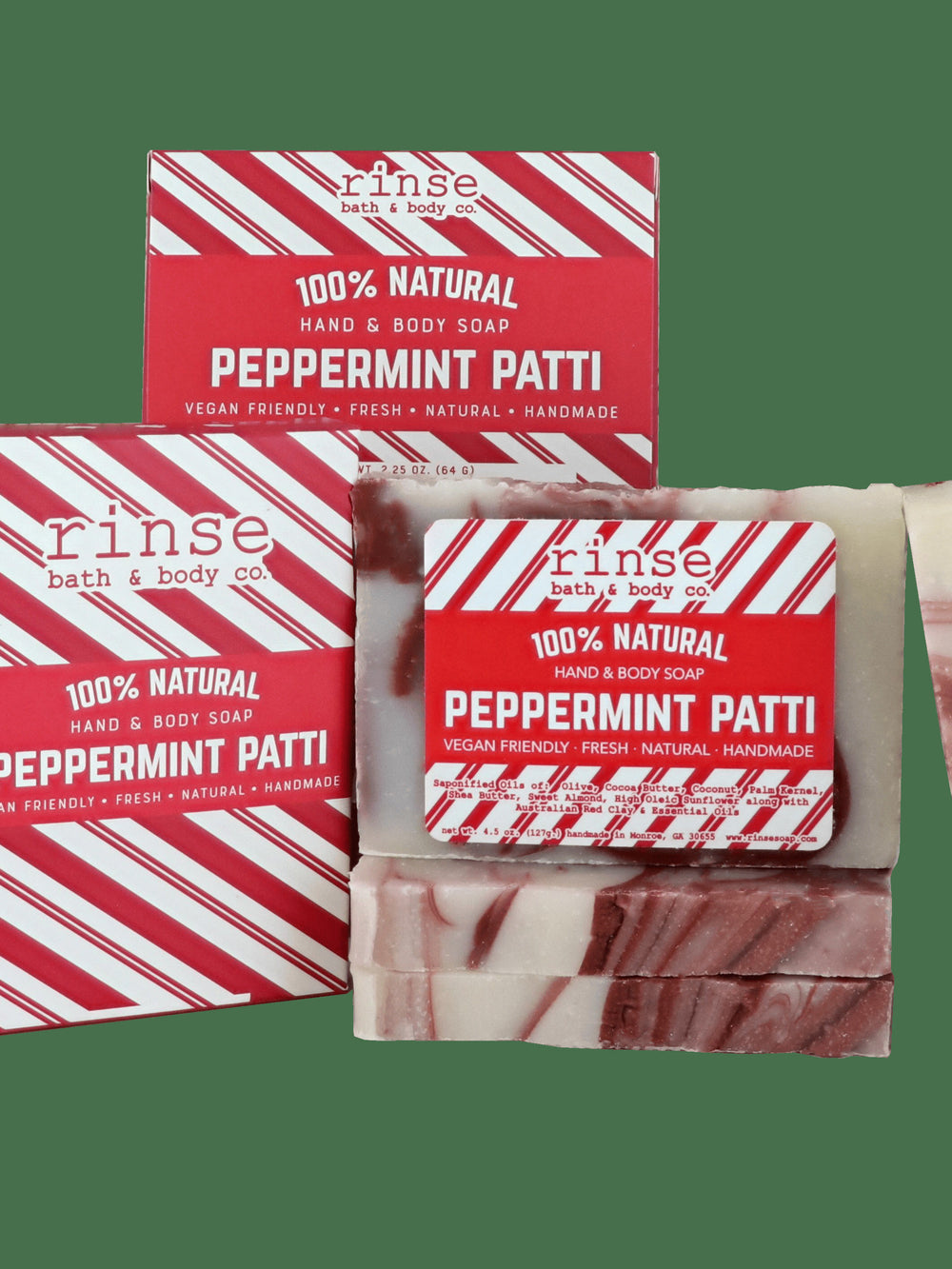 Cream-and-brown Peppermint Patti bars leaning by red-striped boxes — festive packaging on solid dark green