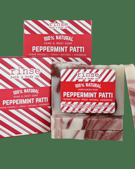 Cream-and-brown Peppermint Patti bars leaning by red-striped boxes — festive packaging on solid dark green
