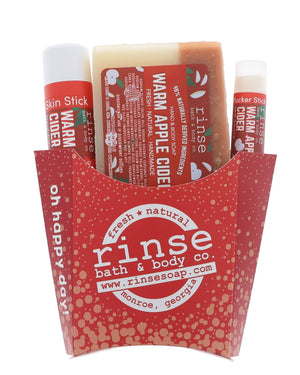 The Warm Apple Cider fry-box gift set open to show its pieces in a kraft fry carton — spiced apple, clove and brown sugar, ready to hand over. Rinse Bath & Body Co.