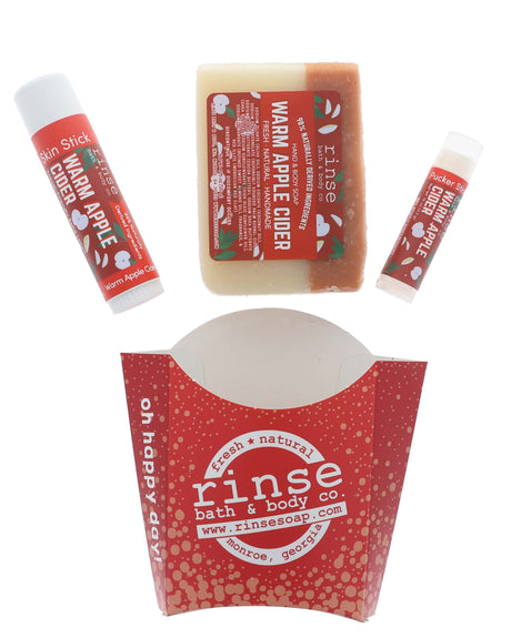 The Warm Apple Cider fry set laid out flat — the pieces and the printed kraft carton they arrive in. Rinse Bath & Body Co.