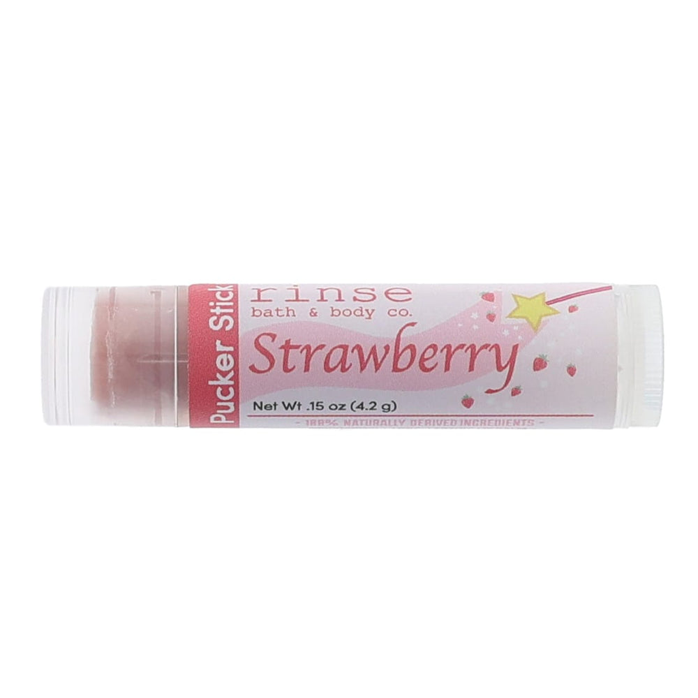Strawberry Pucker Stick lies horizontal — pink wand-and-berry label with terracotta balm on white