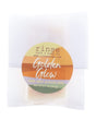 Golden Glow soap slice in translucent glassine — amber-wave circle sticker on clean bright white
