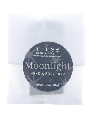 Moonlight soap slice in frosted glassine — black starry circle sticker on clean bright white