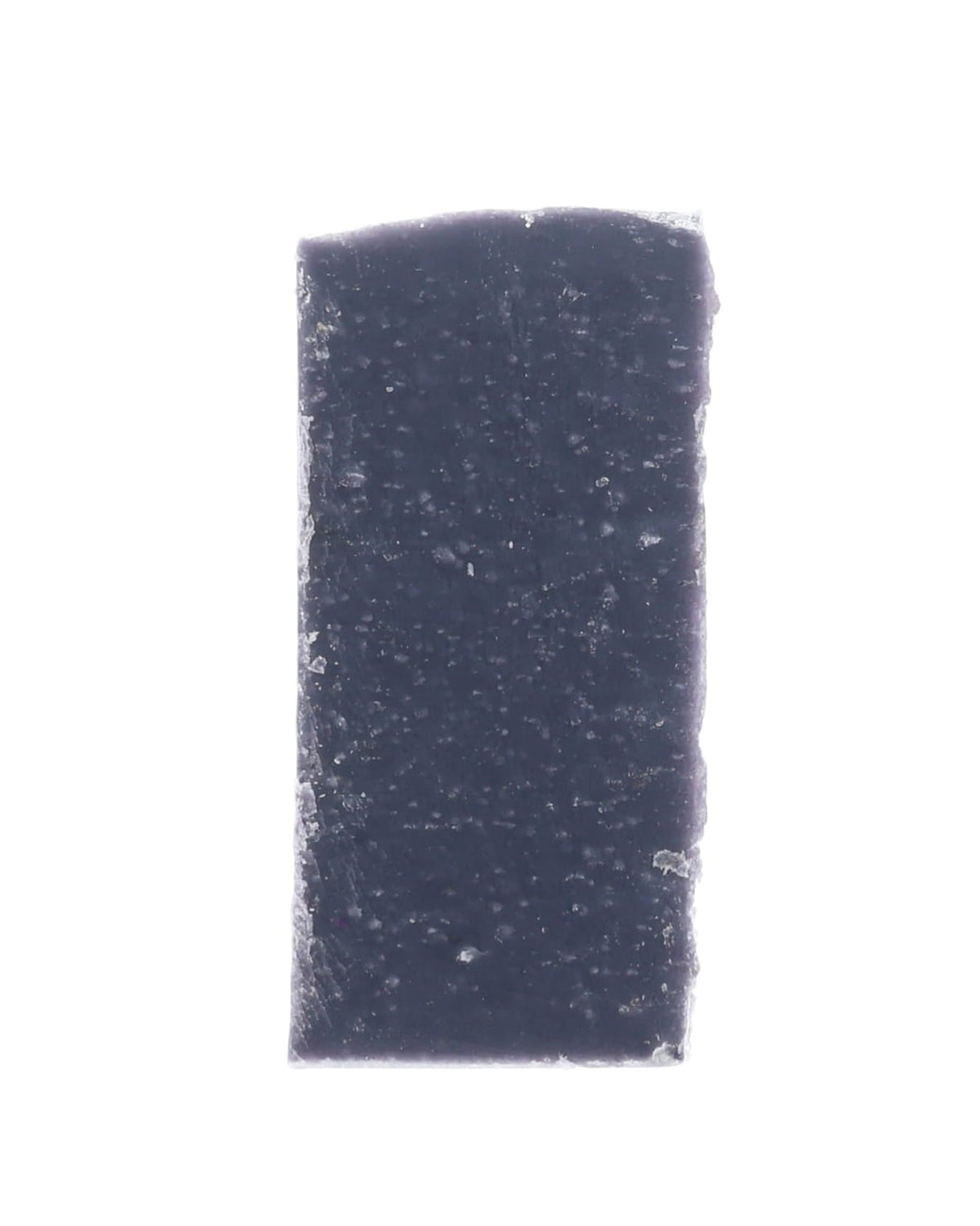 Bare Moonlight soap slice stands dark indigo — crystalline flecks sparkling on stark white