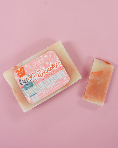 Nutcracker bar and thin slice on dusty pink — cream terracotta marble under soft flat-lay light