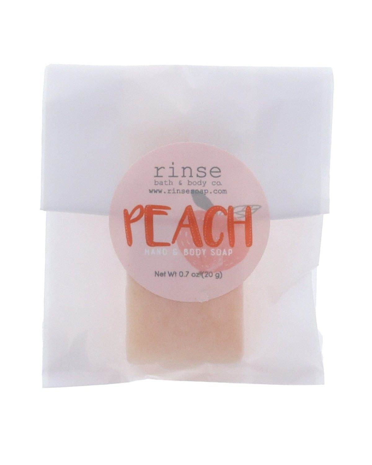 Peach soap slice in translucent glassine — peach circle sticker on clean bright white