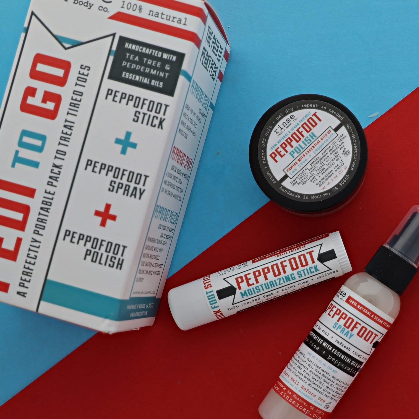 The Pedi-to-Go set laid out on red and blue card — Peppofoot Stick, Peppofoot Spray and Peppofoot Polish with their printed sleeve, the full foot-care routine in one box. Rinse Bath & Body Co.