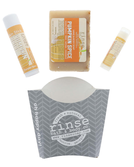 Pumpkin Spice stylized flat lay — bar soap, Skin Stick, and Pucker Stick above gray chevron carton on bright white