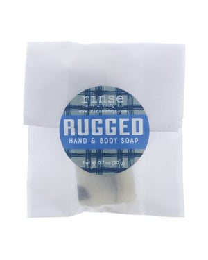 Rugged soap slice in translucent wrap — blue plaid circle sticker on clean bright white
