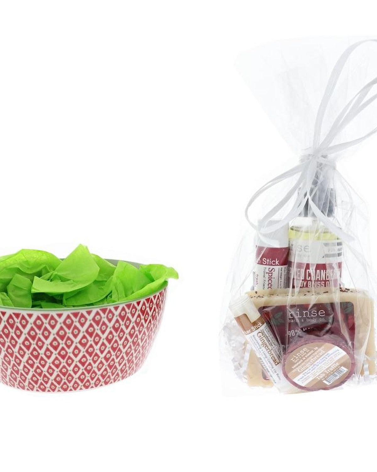 Red diamond ceramic bowl with lime tissue beside a cellophane Spiced Cranberry wrap — soap, Body Bliss oil, sticks, and tub truffle ready to nest