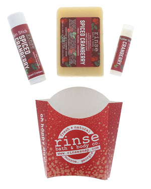 Spiced Cranberry stylized flat lay — bar soap, Skin Stick, and Pucker Stick on bright white with cranberry labels