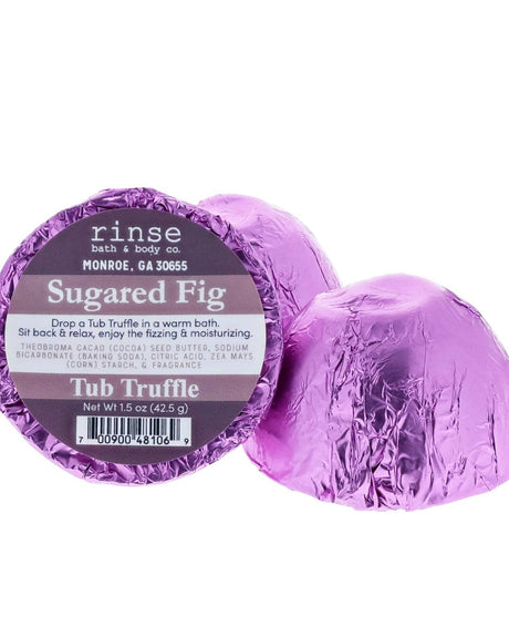 Purple foil-wrapped Sugared Fig Tub Truffles, one cut open to show the cocoa butter dome — vanilla, maple and fig for a cosy soak. Rinse Bath & Body Co.