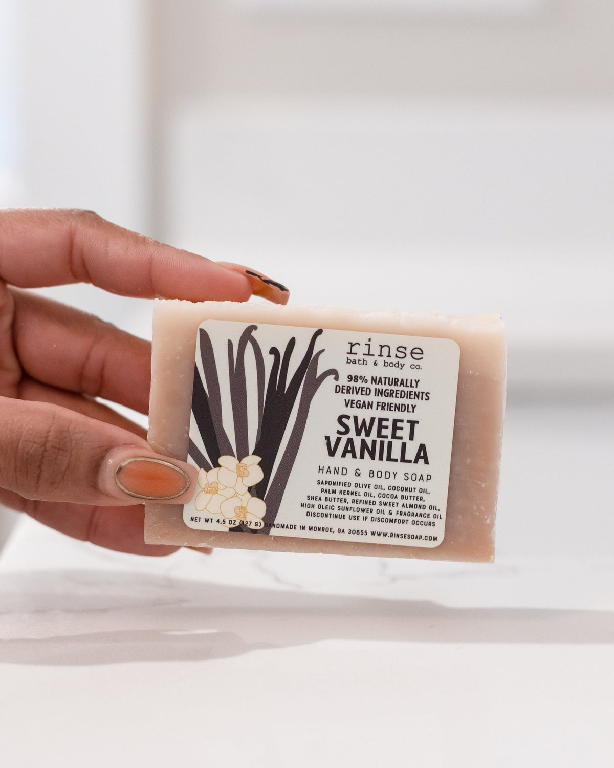 Sweet Vanilla bar soap worked into a creamy lather in hand — warm bourbon-vanilla shower cleanse in use