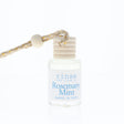 Bottle of 'rinse bath & body co' Rosemary Mint product with a rope on a white background
