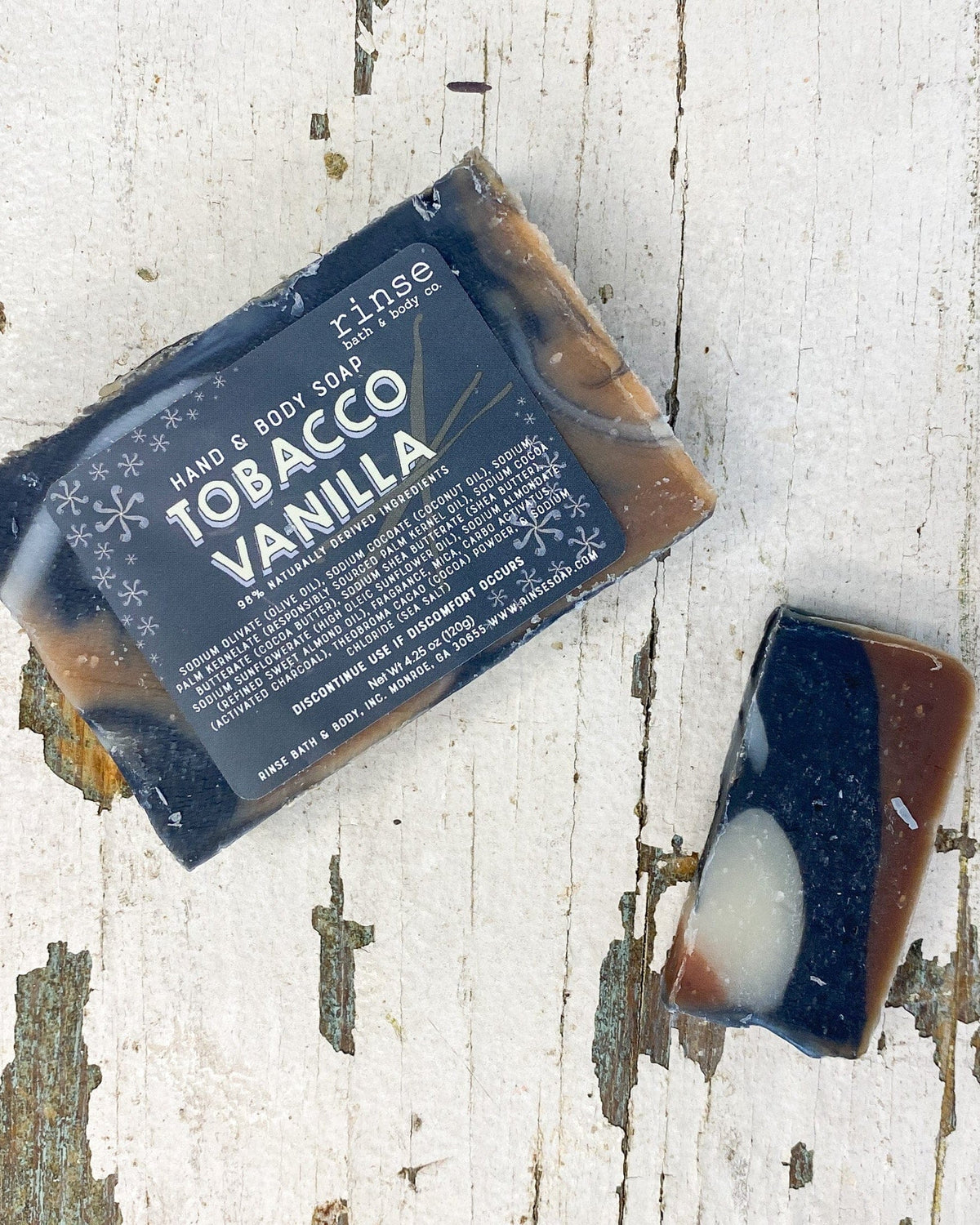 Full Tobacco Vanilla bar and thin slice on peeling white wood — charcoal cream amber marble