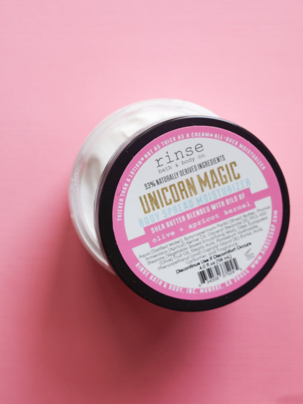 Open Unicorn Magic Body Spread centered on bubblegum pink — buttery white cream in playful top-down light