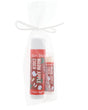 Warm Apple Cider Skin Stick and Pucker Stick standing in sheer white organza — red apple labels in bright studio light