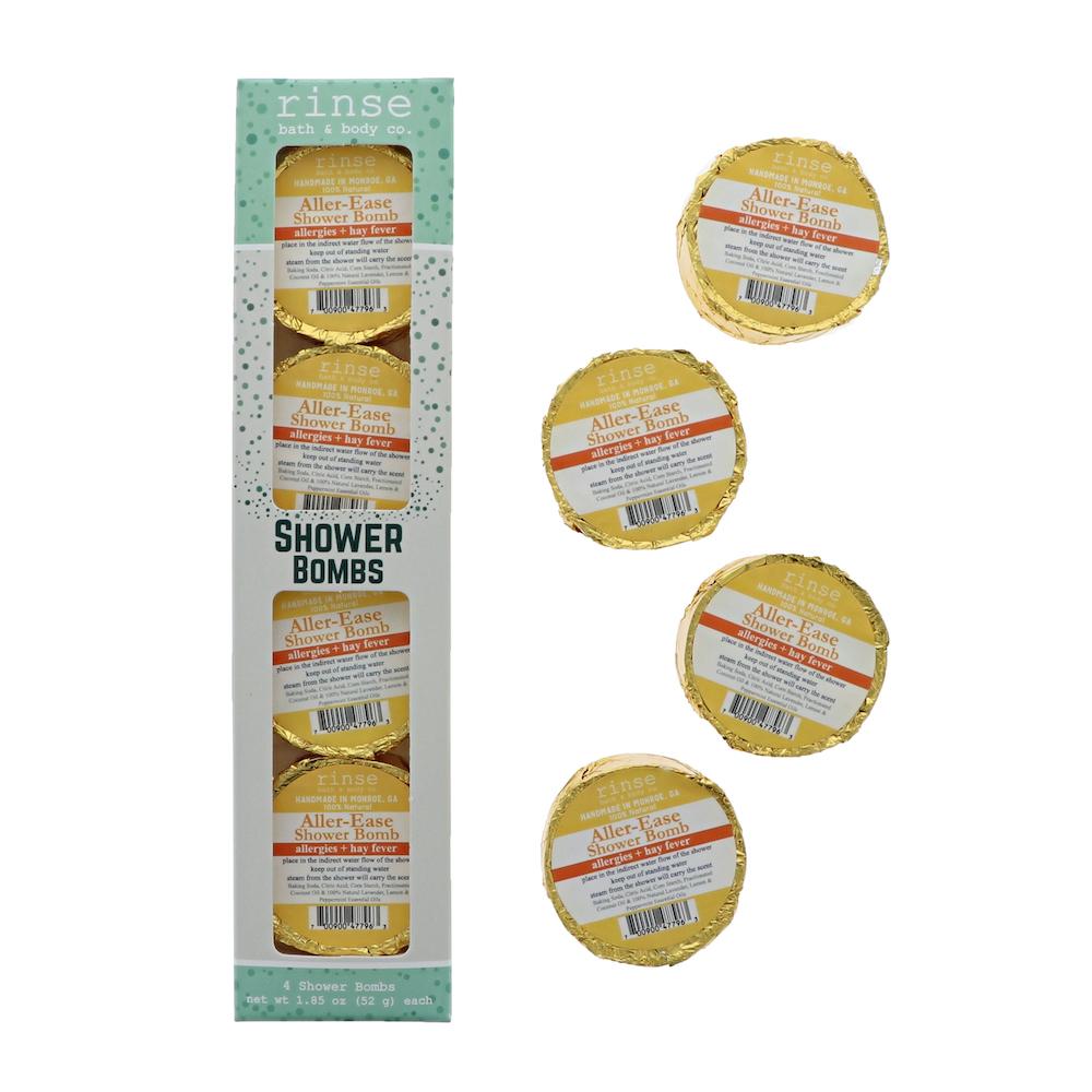 Mint-dotted Aller-Ease 4-pack carton stands beside four gold-foil shower bombs — bright clean white studio