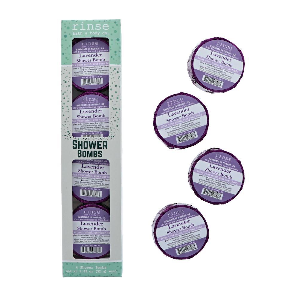 Lavender 4-pack carton stands beside four purple-foil pucks — scattered on clean bright white
