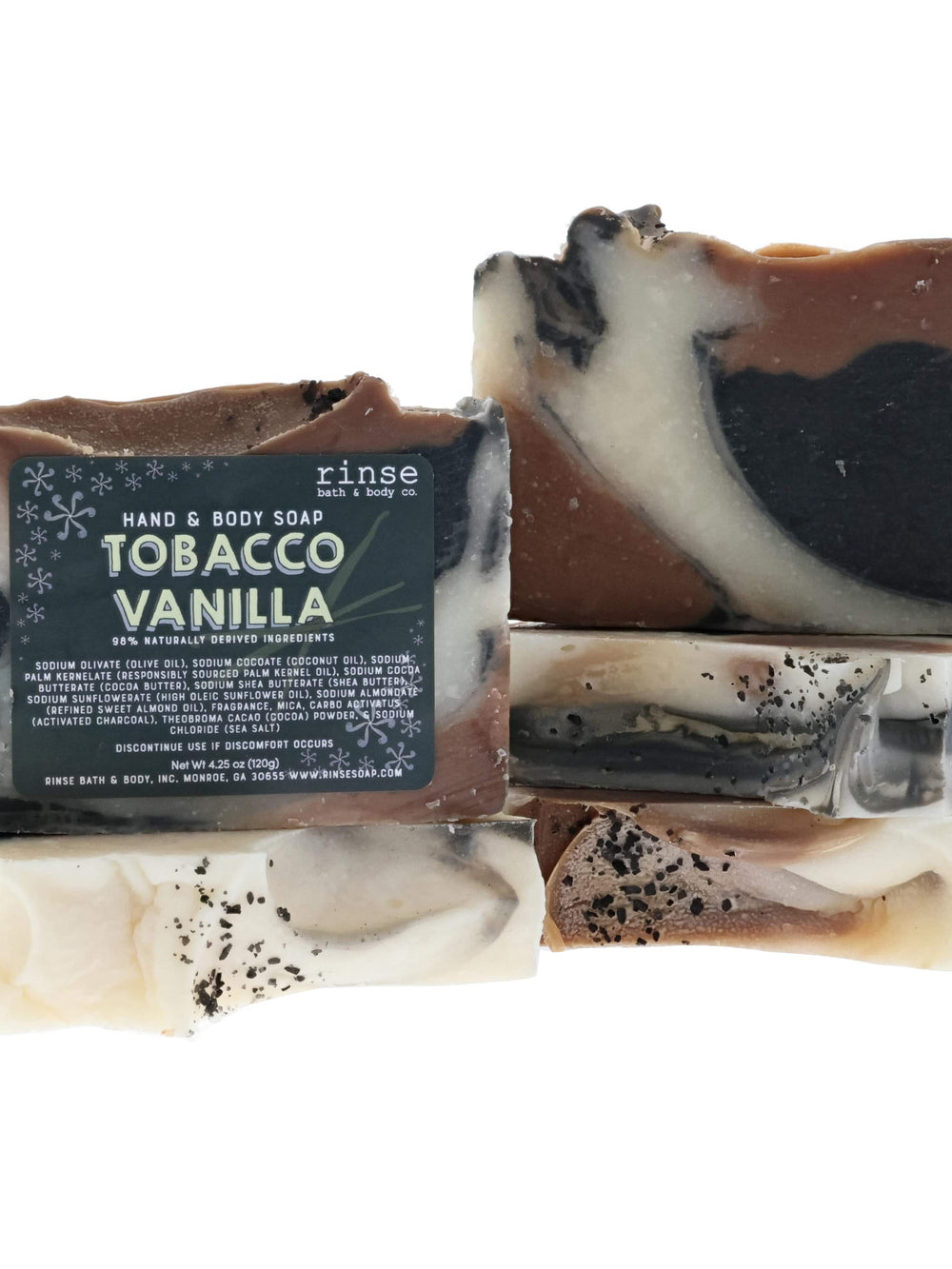 Tobacco Vanilla handmade bar soap, deep charcoal with its cream label — smoky vanilla and tonka in a cocoa-butter base. Rinse Bath & Body Co.