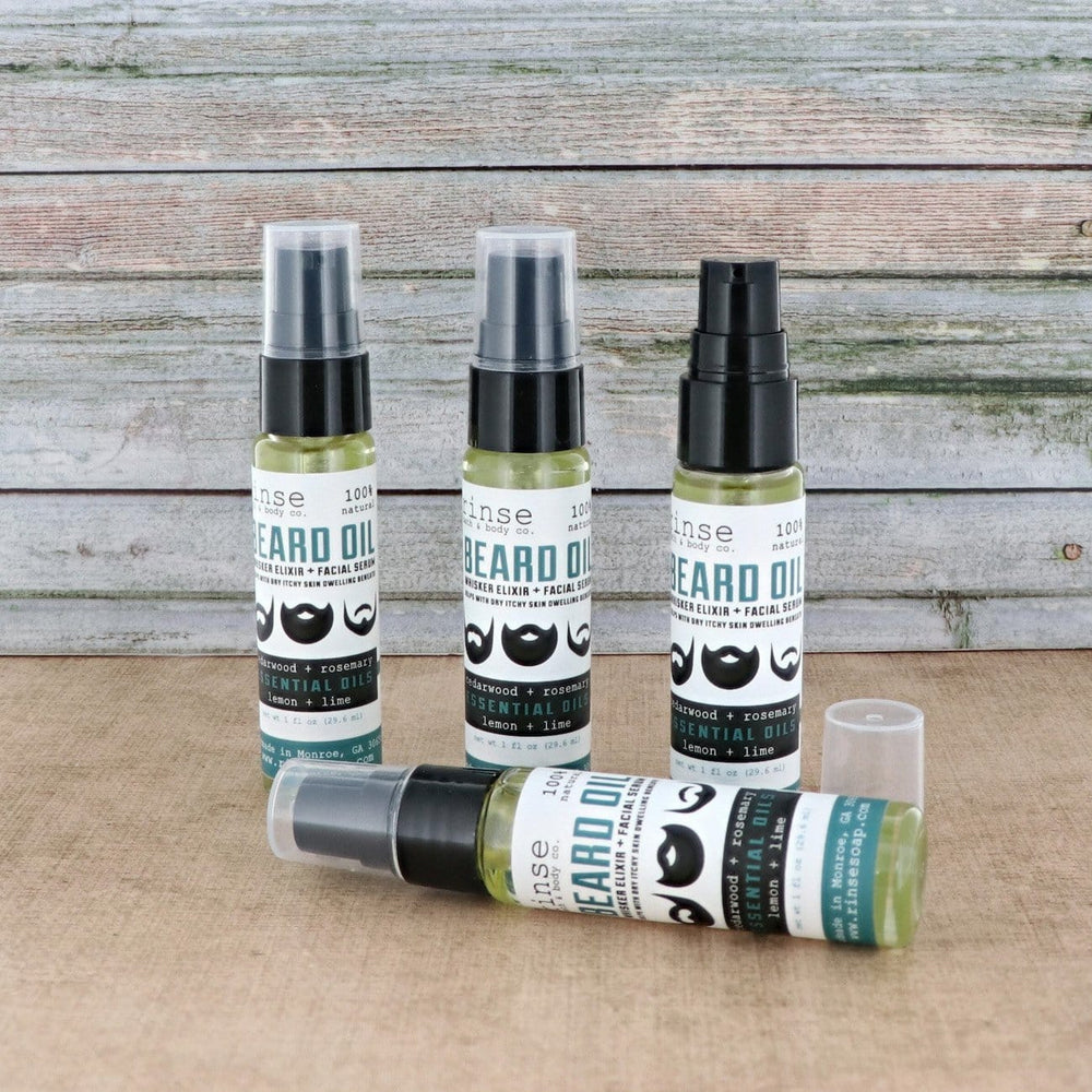 Four Beard Oil bottles on coarse burlap against weathered wood planks — one lying forward with woodsy citrus whisker elixir in bright light