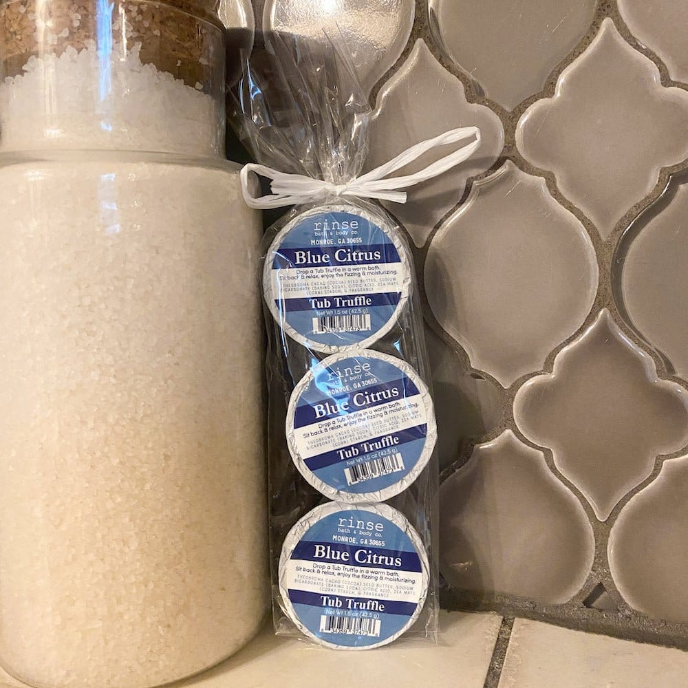 Blue Citrus Tub Truffle 3-pack stands beside a jar of bath salts — grey ogee tile behind
