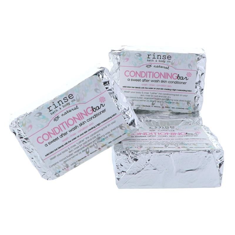 Three foil-wrapped Conditioning Bars clustered on white — silver crinkle packs with magenta labels in clean studio light