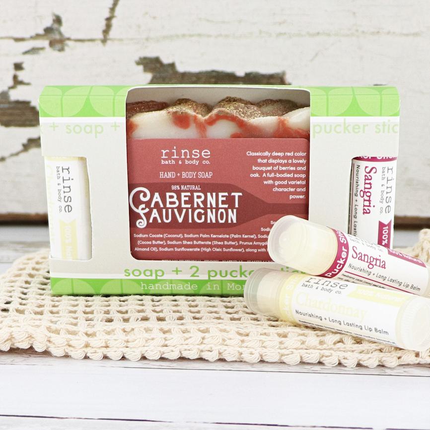 Cabernet soap and Sangria-Chardonnay pucker sticks nest in a lime-green patterned box on crocheted cream mat.