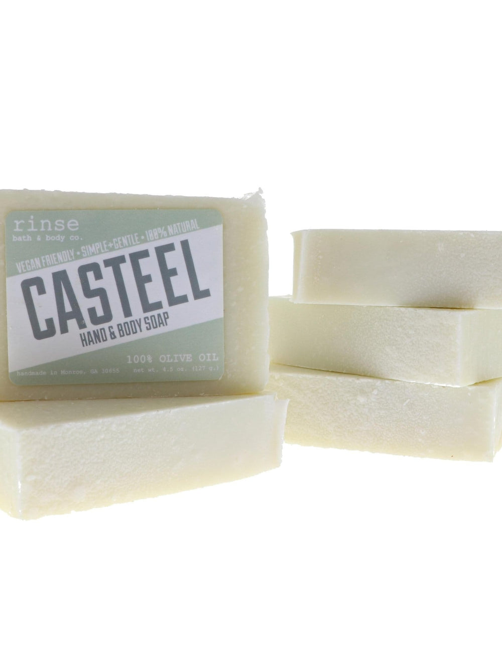 Stacked Casteel bars show thick creamy sides — olive-oil label crisp on stark white