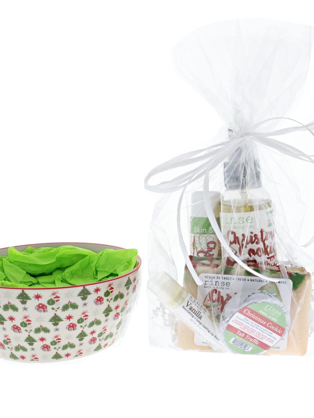 Tree-berry ceramic bowl with lime tissue beside its Christmas Cookie cellophane set — spray Tub Truffle lip balm and soap on white