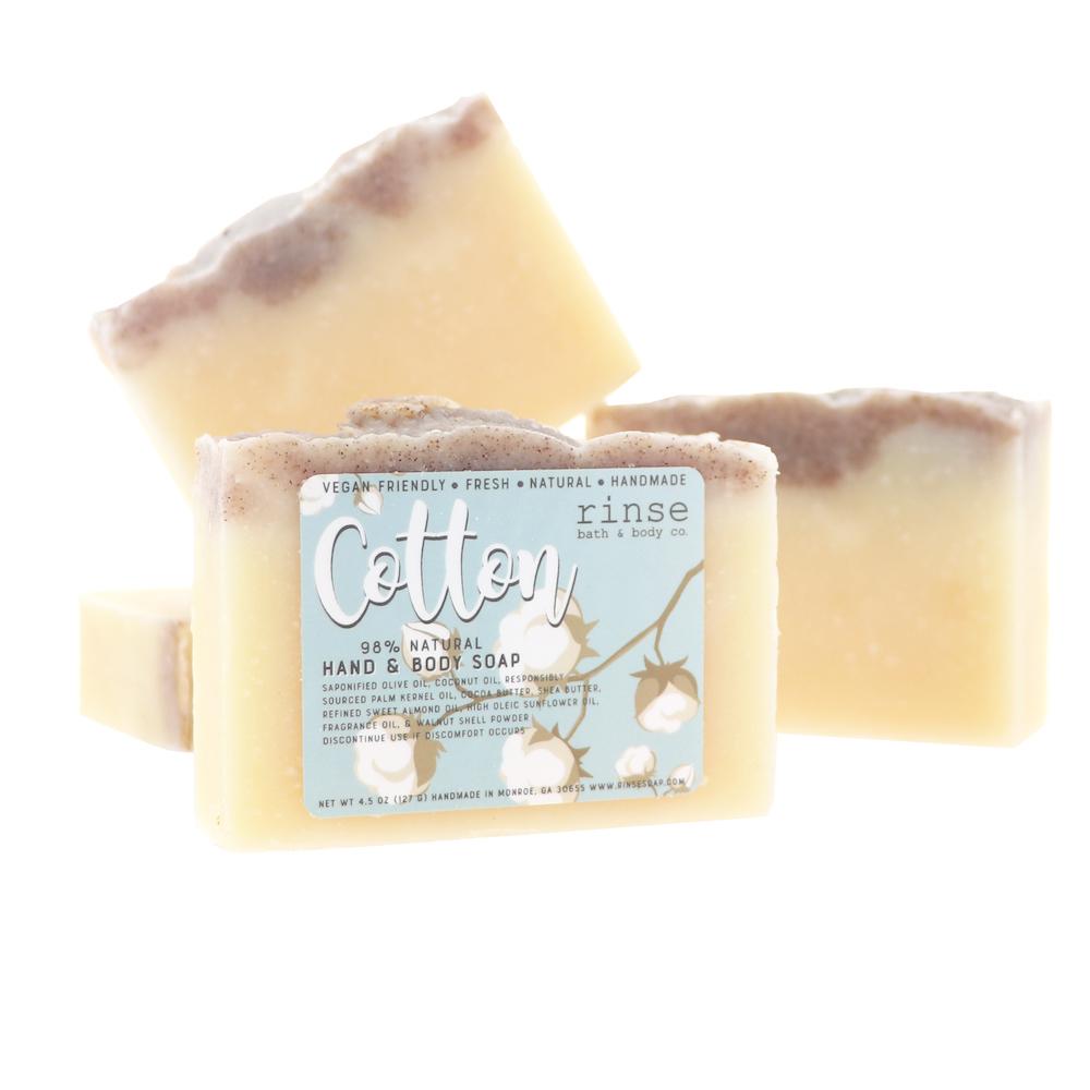 Cotton soap stack shows cream body and dark exfoliating crest — cotton branch art on stark white