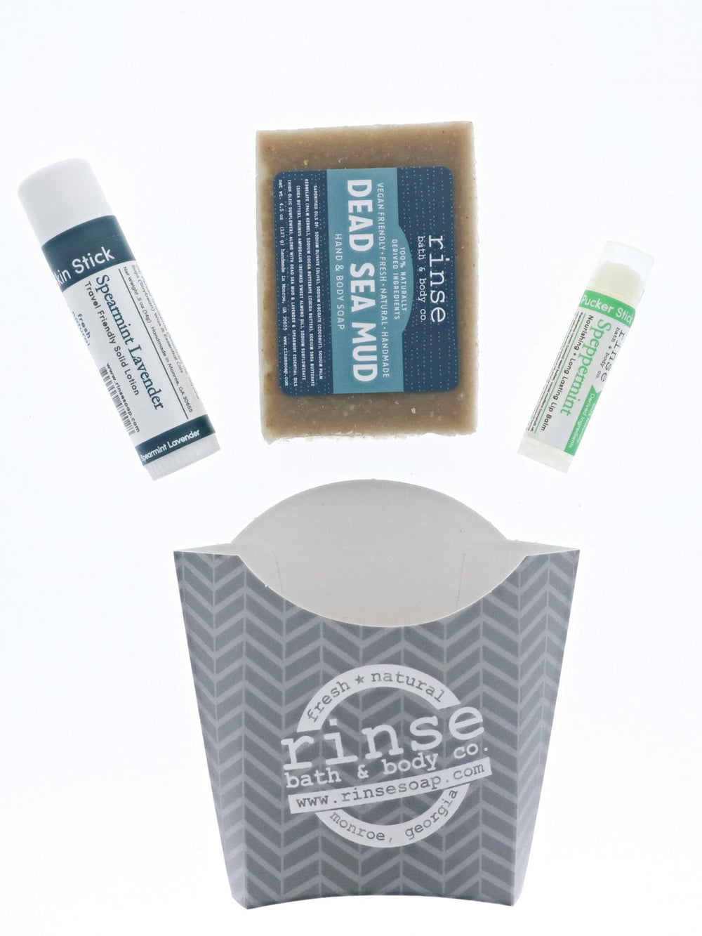 The Dead Sea Mud set laid out flat — bar soap, Spearmint Lavender solid lotion stick and Speppermint lip balm above the grey chevron carton. Rinse Bath & Body Co.